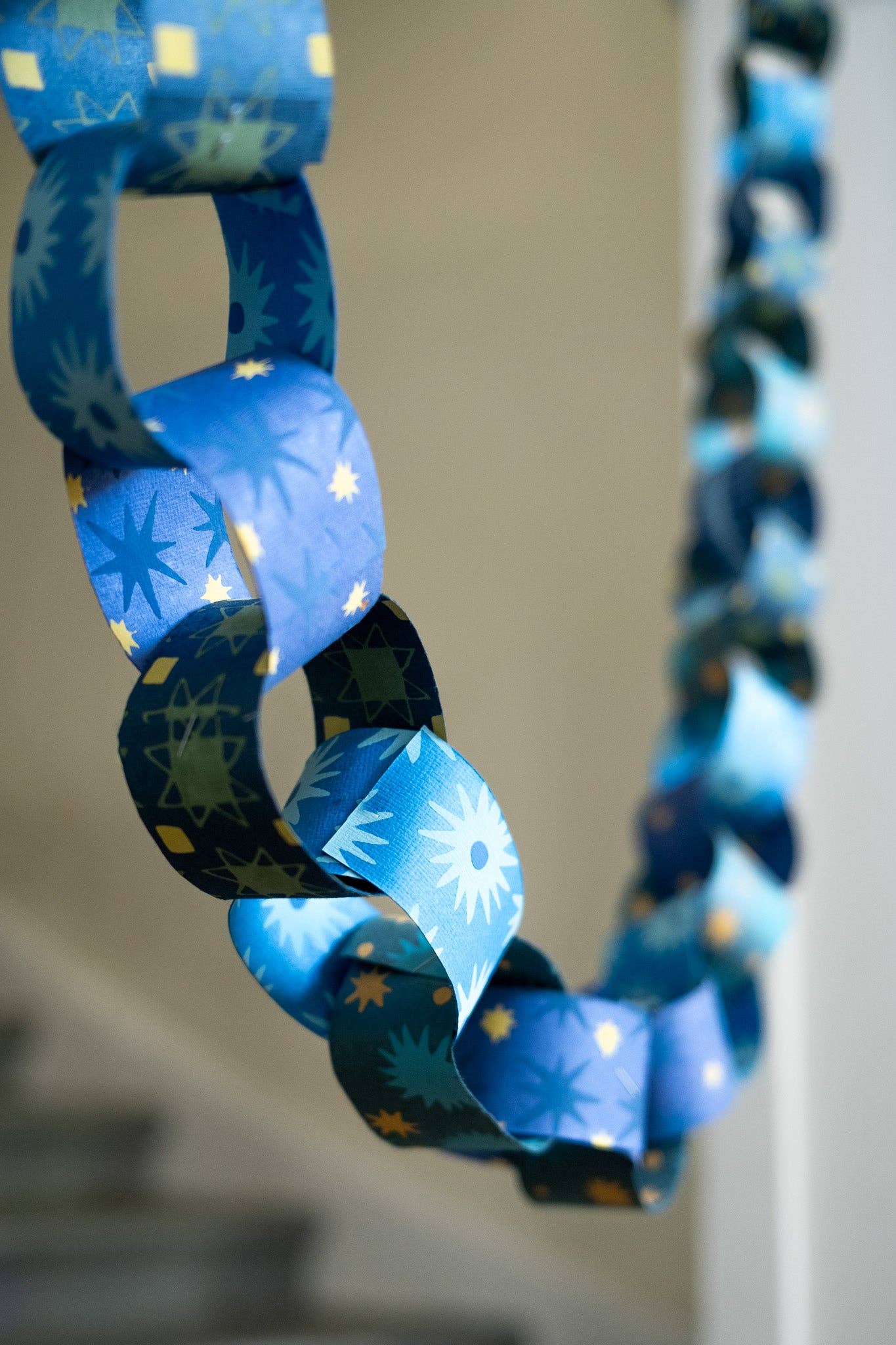 Single loop of a blue and yellow recycled paper chain, showing texture