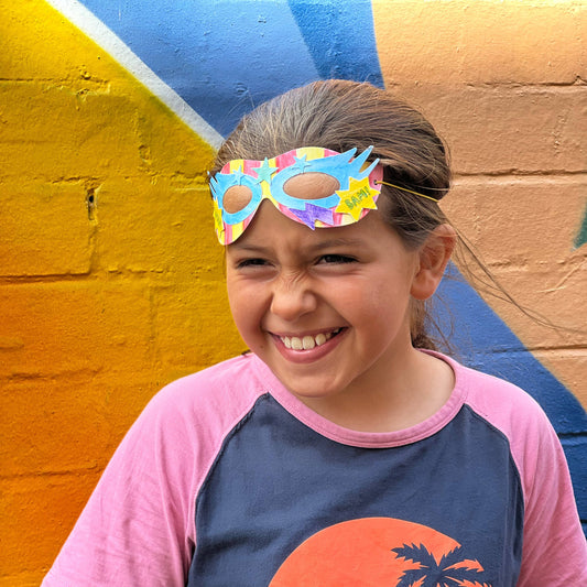 Child decorating a sustainably sourced superhero mask