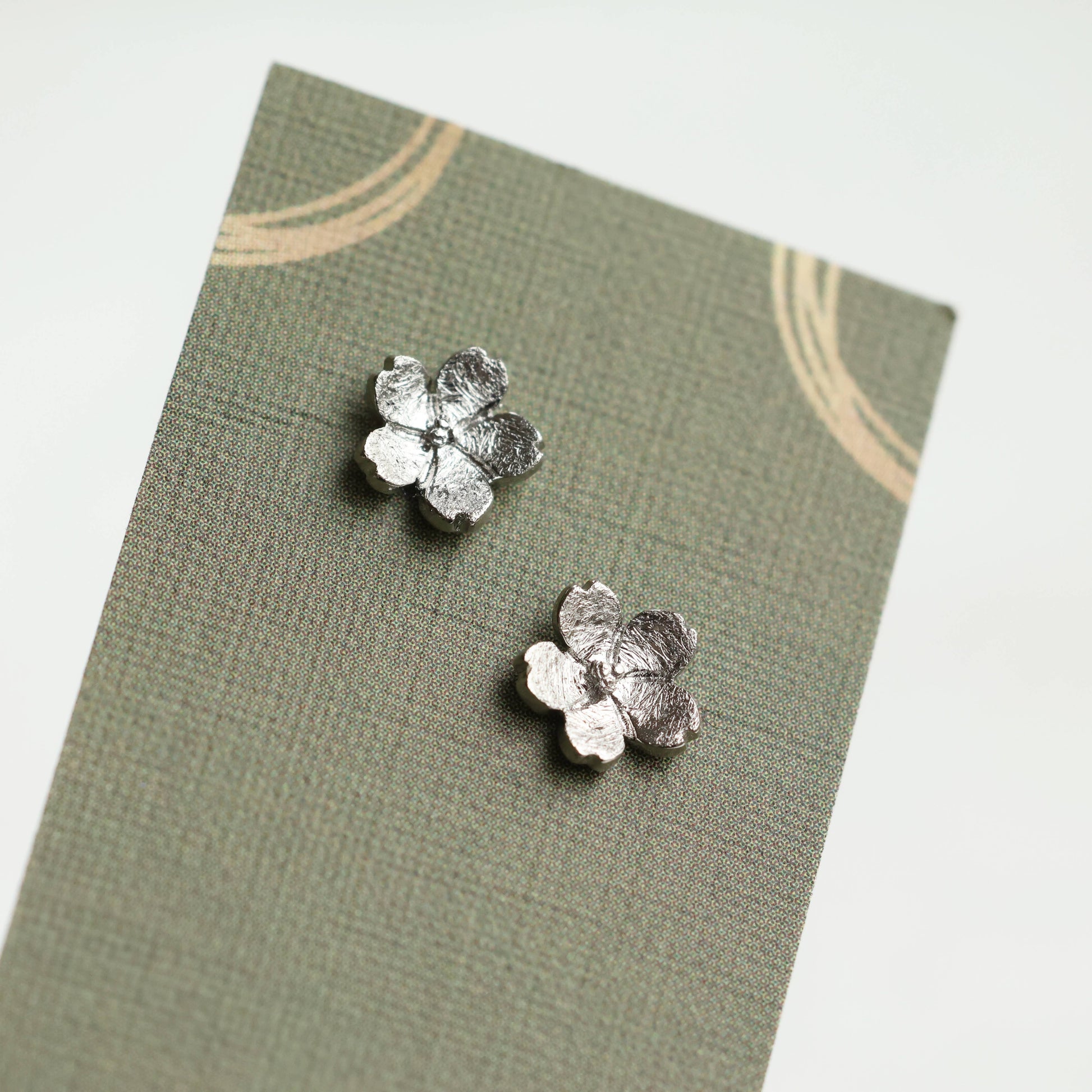 These sweet and dainty stud earrings feature a pair of tiny forget me not flowers, made from Sterling Silver with a subtle brushed texture. The earrings measure 9mm in diameter. These stud earrings come mounted on a linen presentation card.