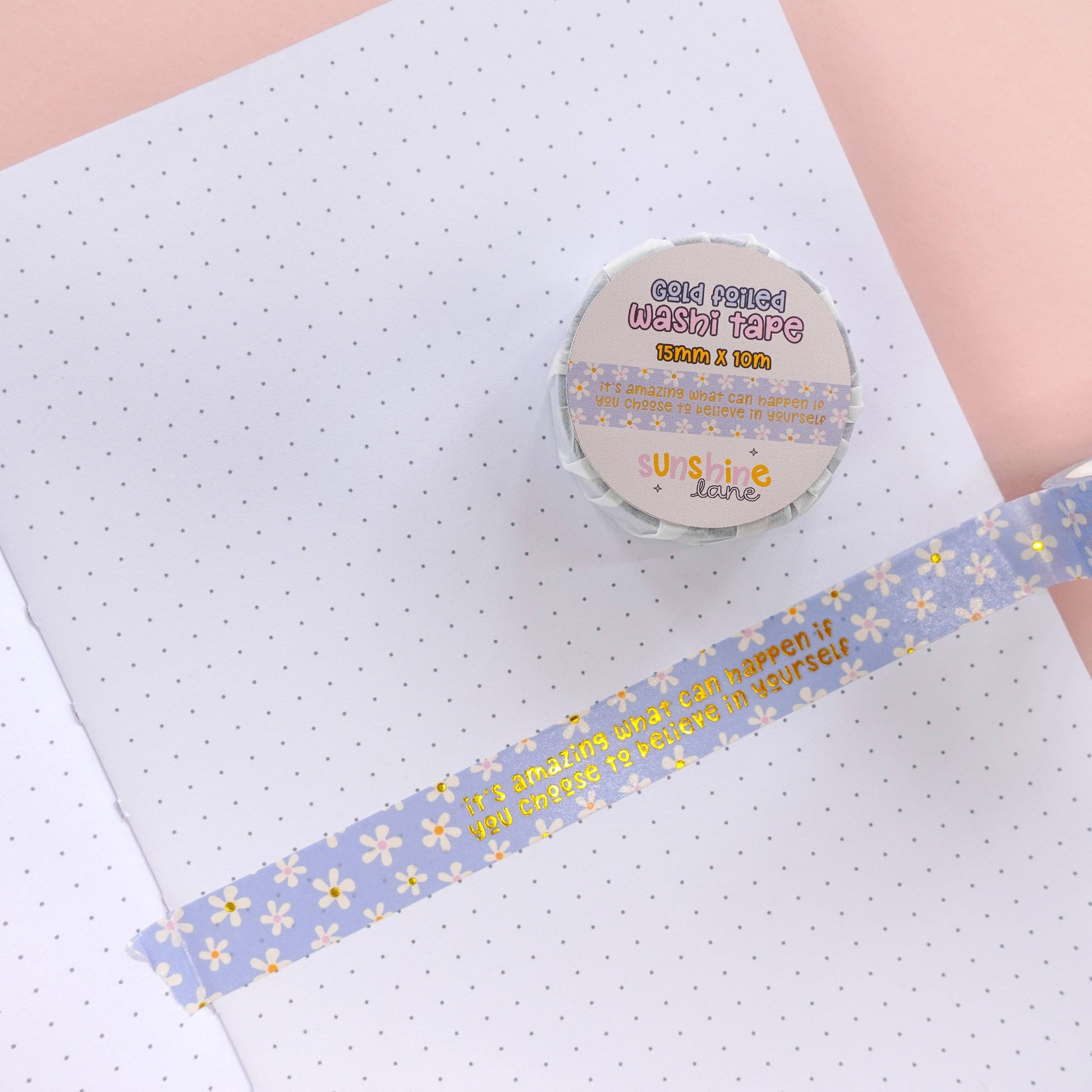 Close-up of gold foil quote on blue floral washi tape