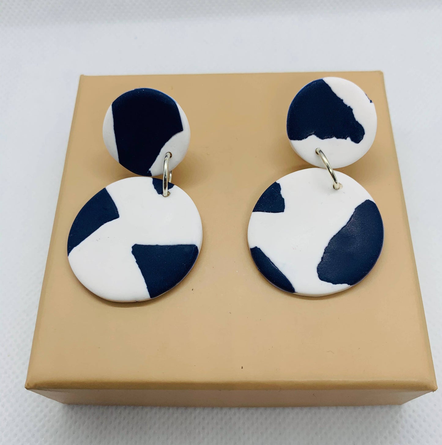 Model wearing Catalina blue and white polymer clay drop earrings, showcasing their statement size and elegant design.