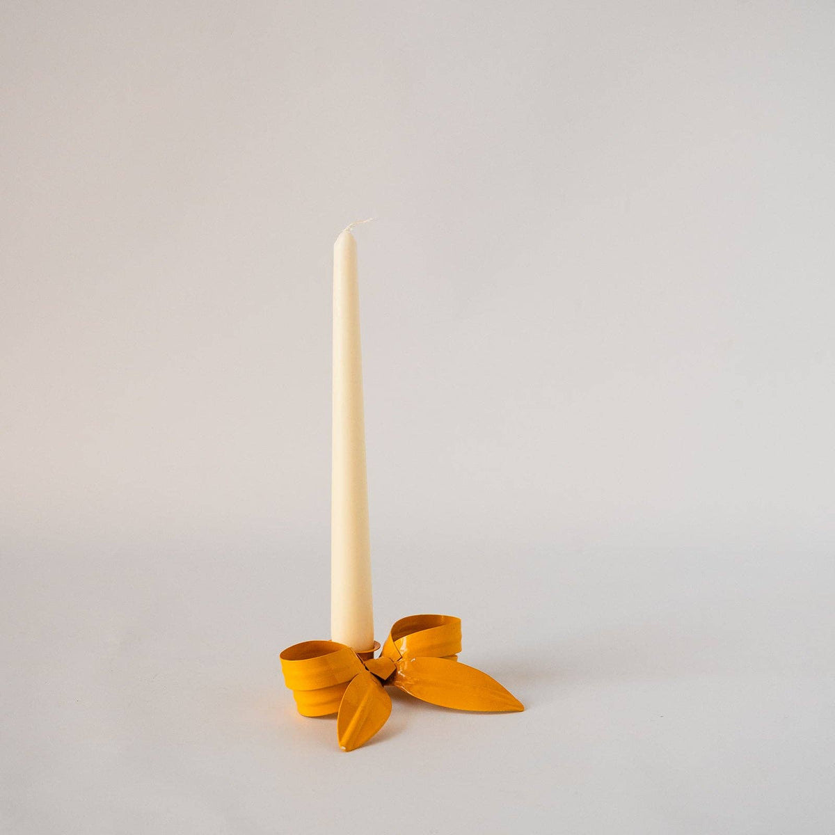 Grouped colourful Ribbon Bow Candlestick Holders on a mantelpiece