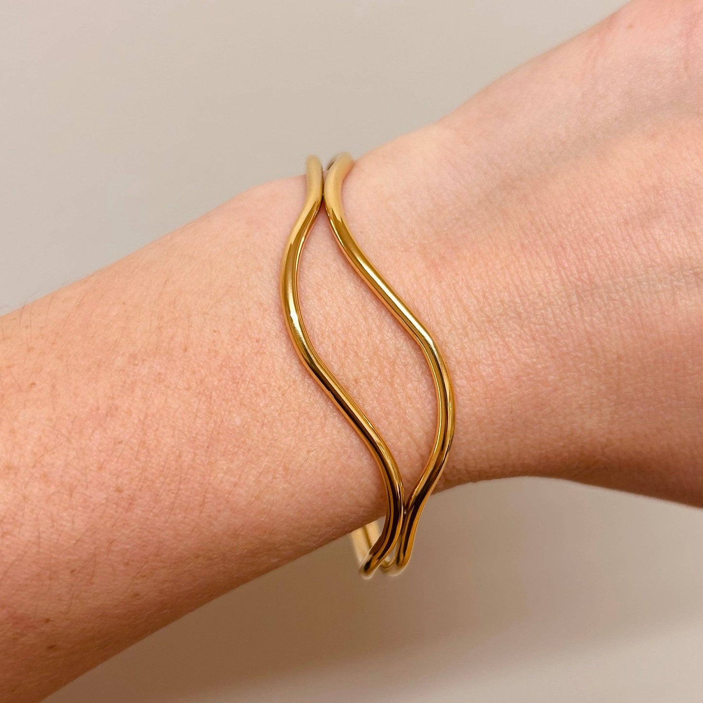 Model wearing 18k gold plated abstract bangle, adjustable design