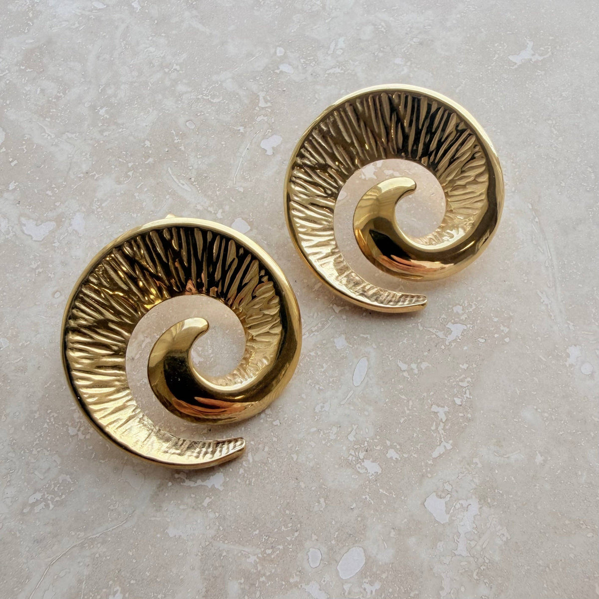 Close up of waterproof gold plated swirl earrings