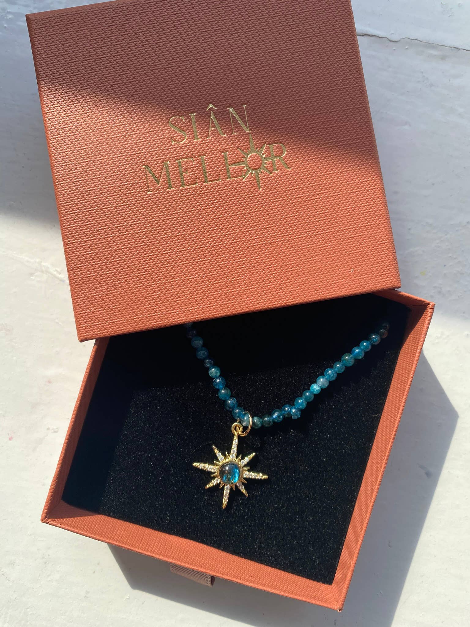Close up of blue beads and gold star pendant on necklace