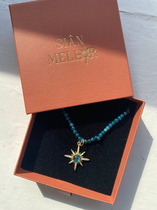 Close up of blue beads and gold star pendant on necklace