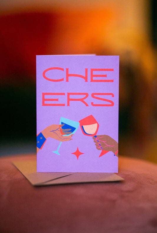Colourful greeting card featuring two wine glasses clinking in a cheers