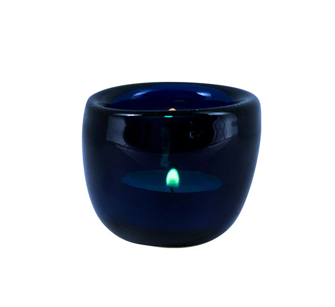 A collection of hand-blown glass tealight holders in assorted colors, including blue, green, and purple, with etched designs on the base.