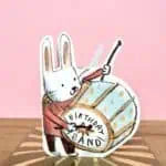 Eco-friendly die-cut birthday card featuring a drumming bunny
