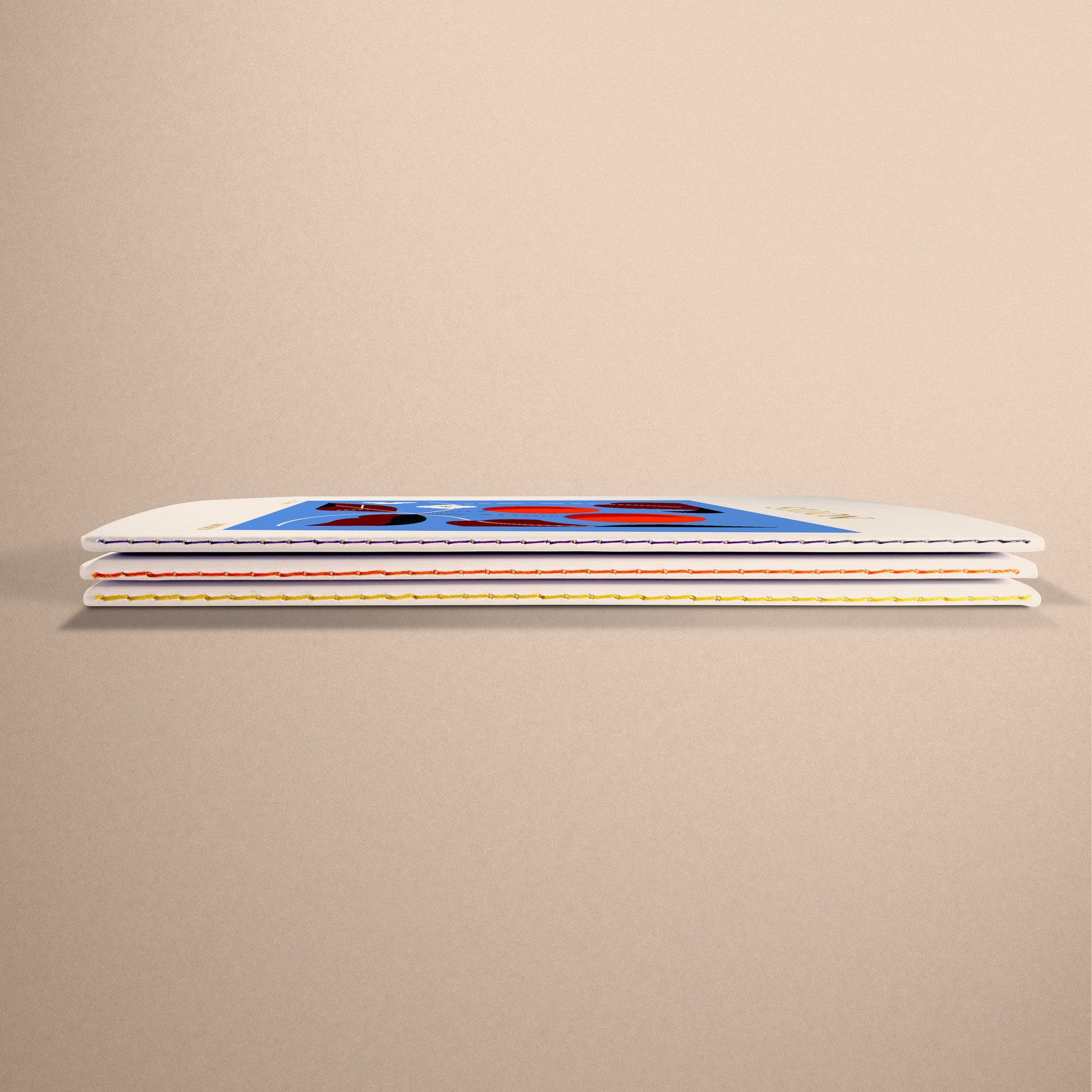 Stack of Darling Clementine A5 stitched notebooks with colourful fruit designs, showcasing their sustainable quality and gold foil details.