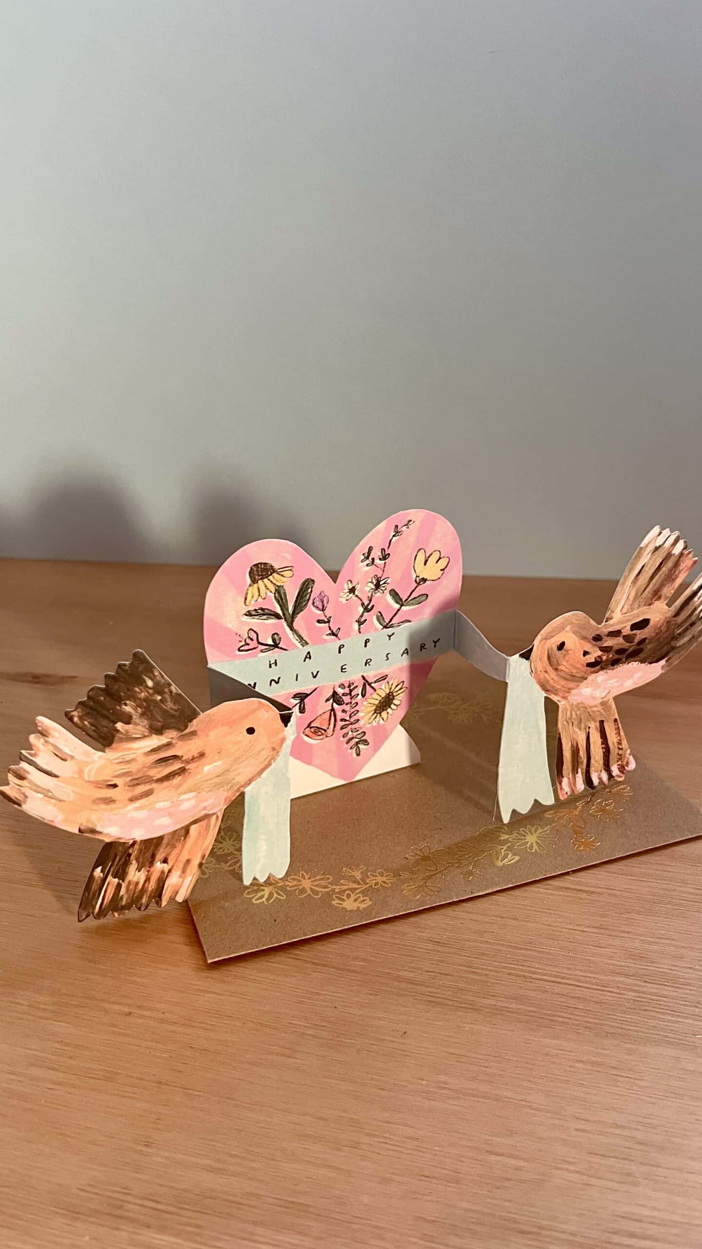 Anniversary Birds Greeting Card by Laura Skillbeck featuring two brown birds and a floral heart