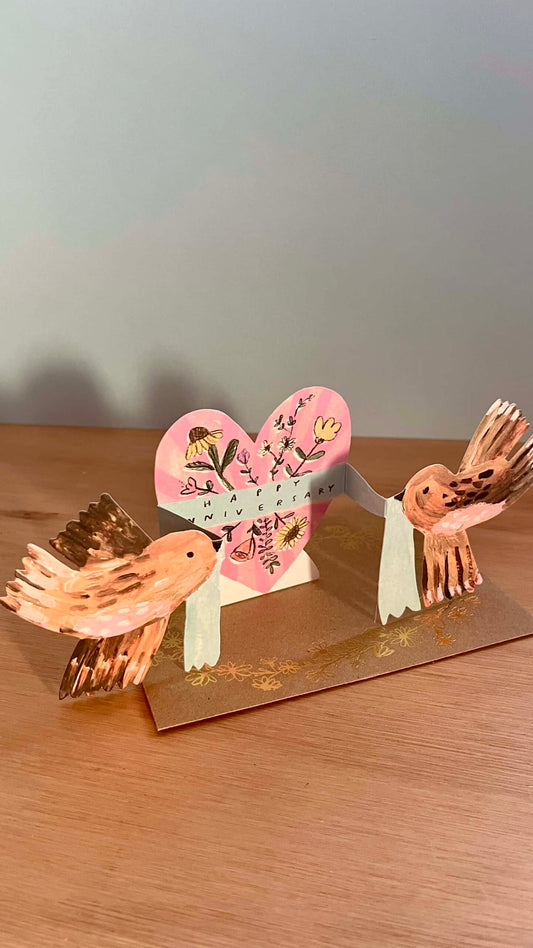 Anniversary Birds Greeting Card by Laura Skillbeck featuring two brown birds and a floral heart