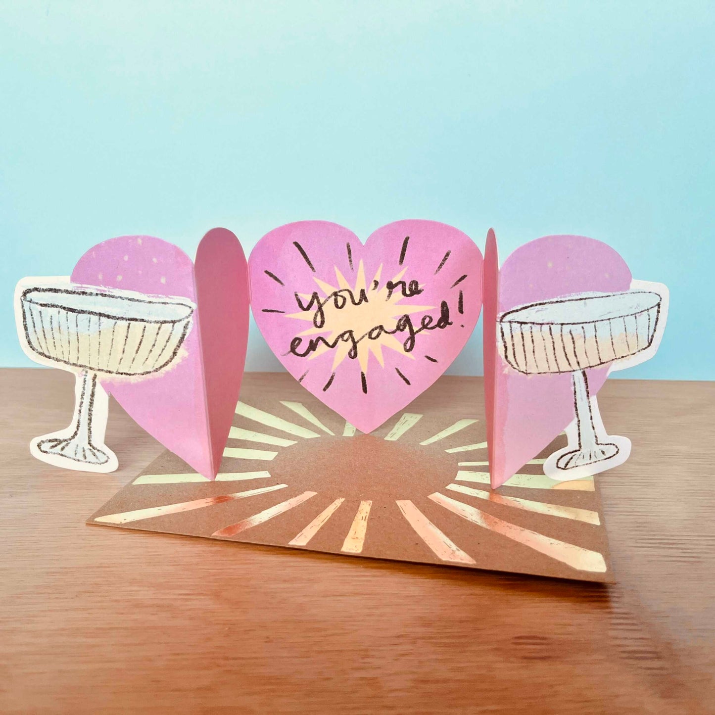 Clinking champagne glasses die-cut recycled engagement card by Laura Skillbeck