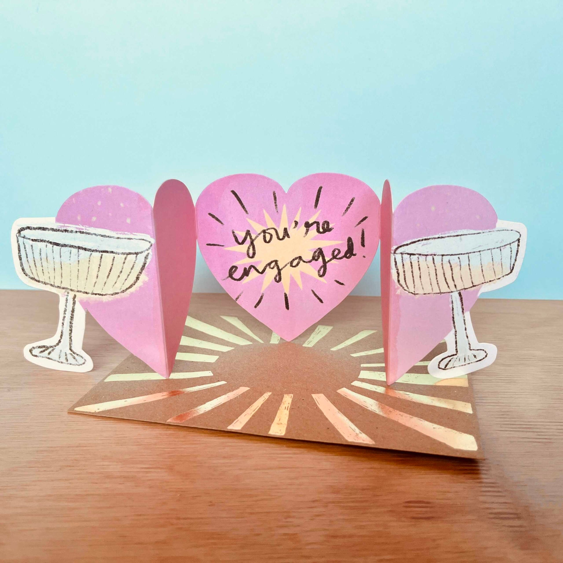 Clinking champagne glasses die-cut recycled engagement card by Laura Skillbeck