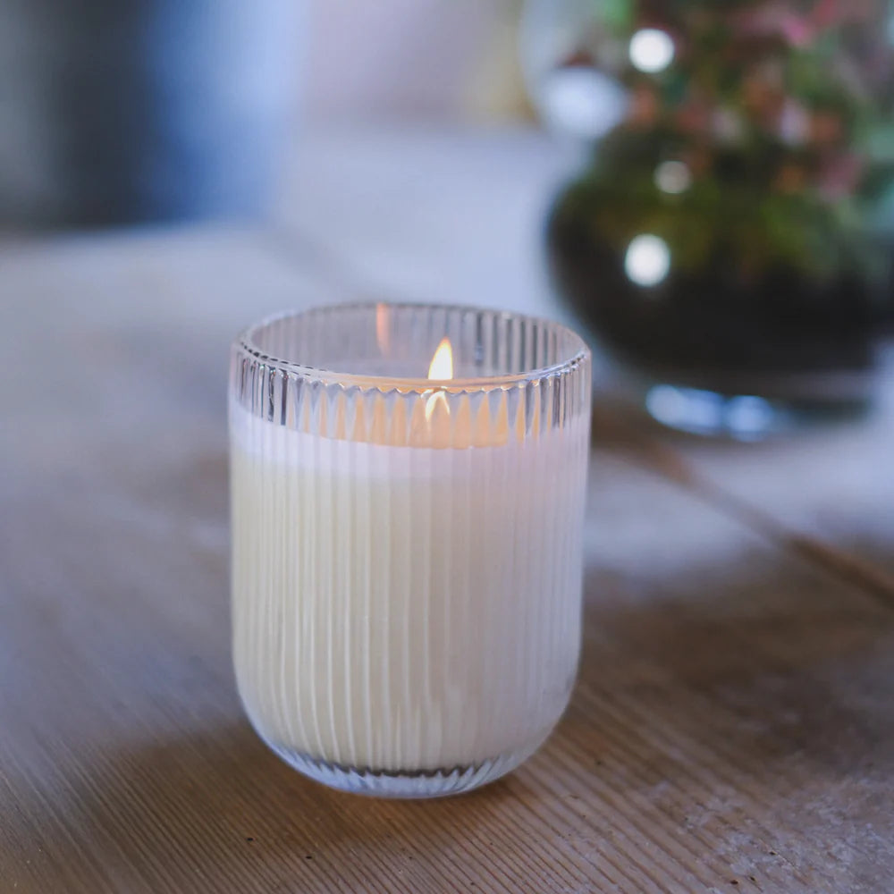 Close-up of HÆFEN Lemongrass Soy Wax Candle with flame, showing ribbed glass texture