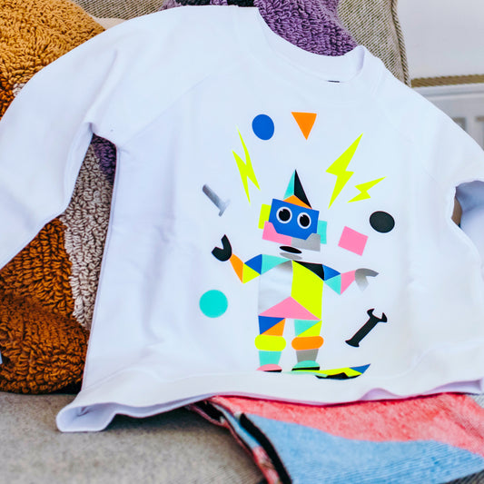 Child applying robot design print to fabric with POPKIT tools