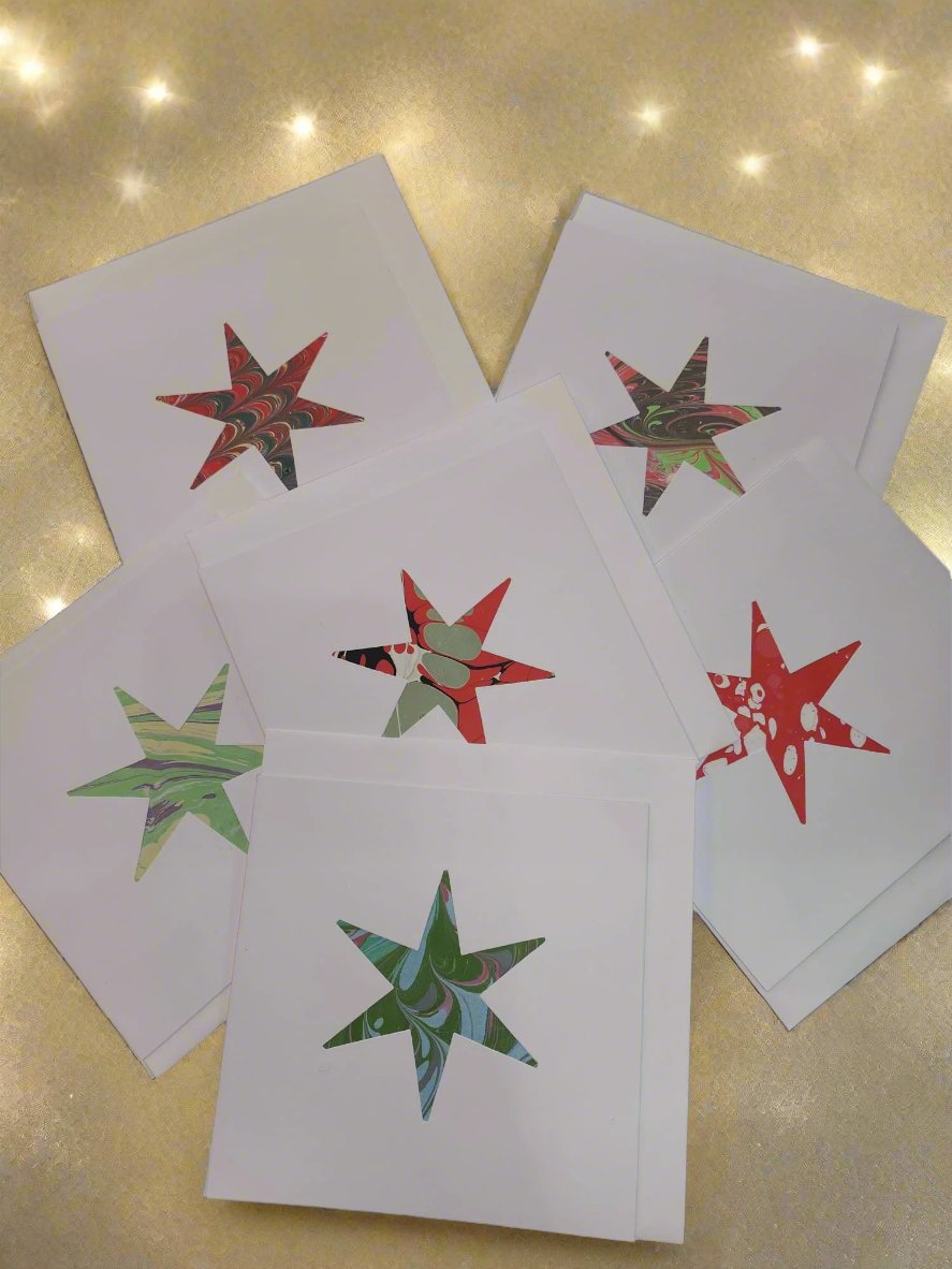 Handmade marbled cards, from local Herne Hill card designer Jane Darling. Featuring a cut out marble star, which makes it perfect as a beautiful handcrafted Christmas card.

Featuring a cut out shape with a marbled insert, in a variety of colourways, each card is unique.
14 x 14 cm