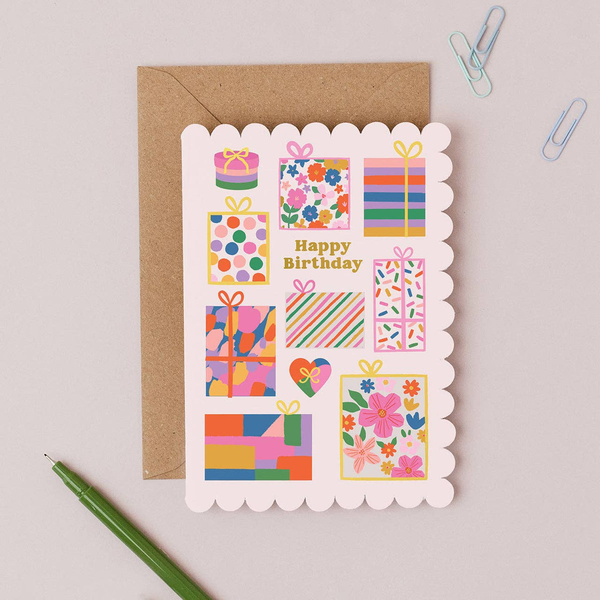 Gorgeous Gifts Birthday Card featuring a stack of colourful presents with gold foil accents and scalloped edges