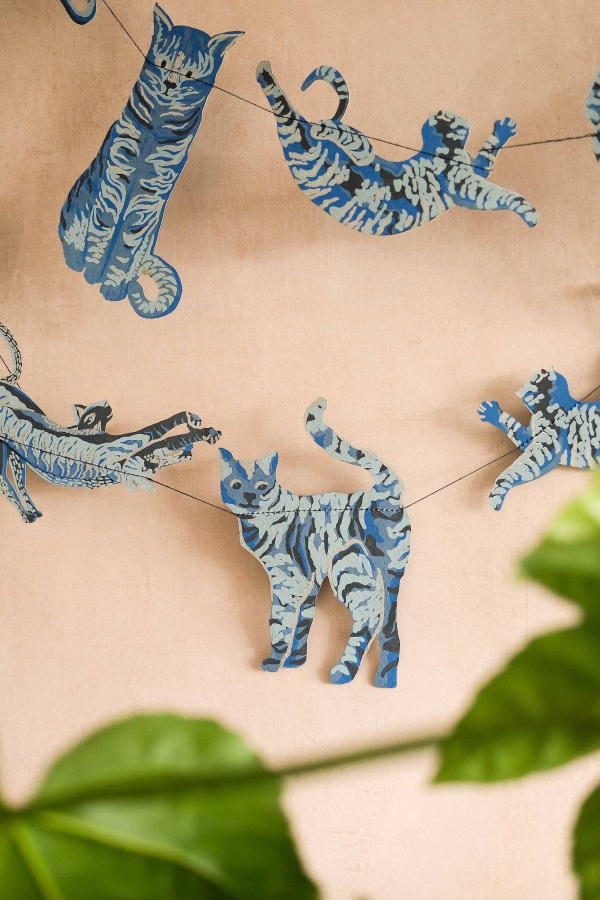 Close up of hand screen-printed recycled paper cat garland