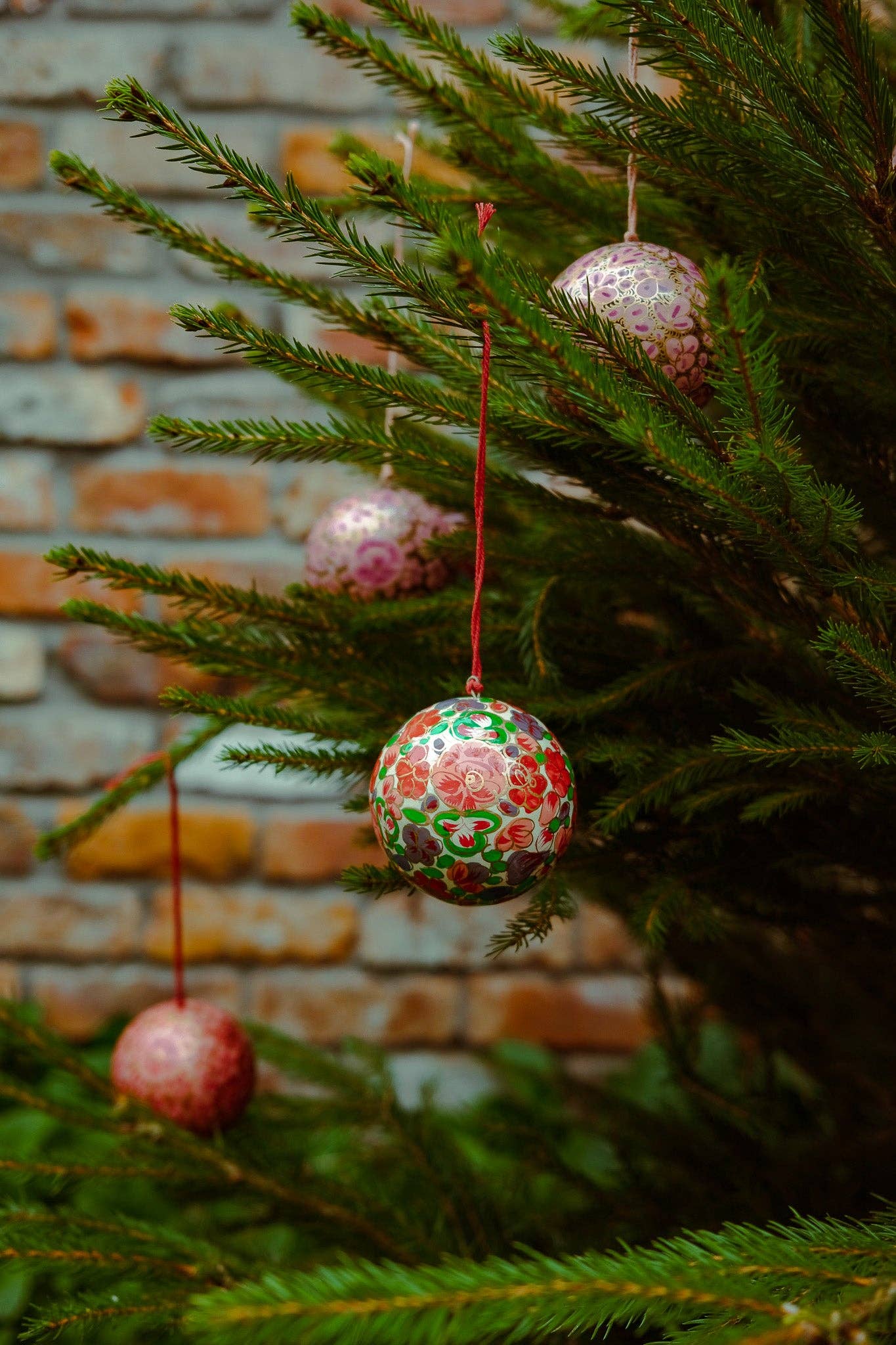Crimson flower bauble on a natural wooden surface