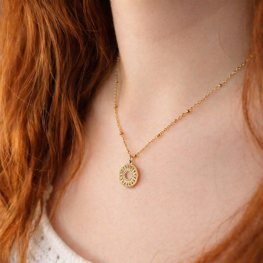 Close up of gold mandala charm and adjustable chain