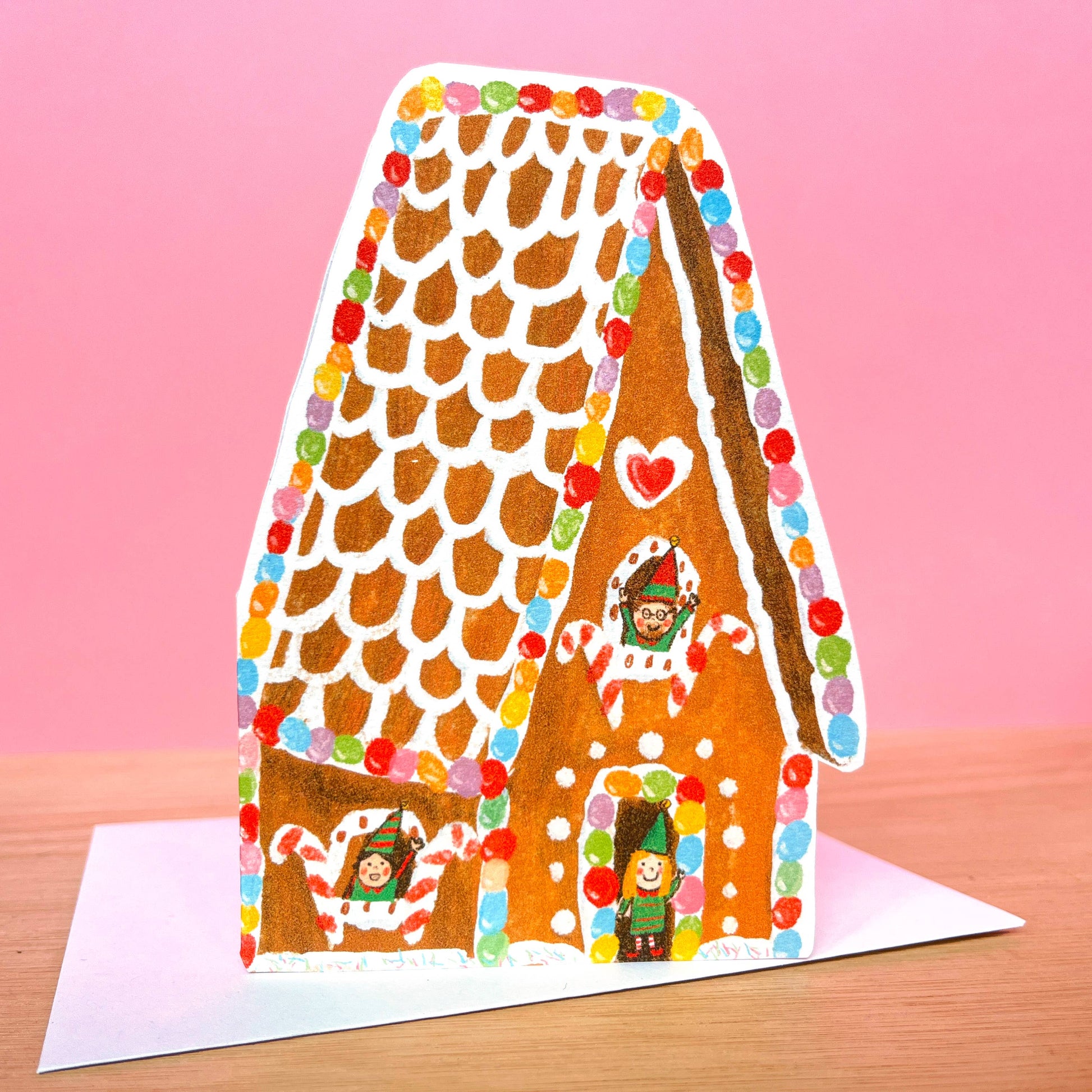 Gingerbread House Christmas card, eco-friendly, shaped, with festive elves waving from windows, handmade in UK.
