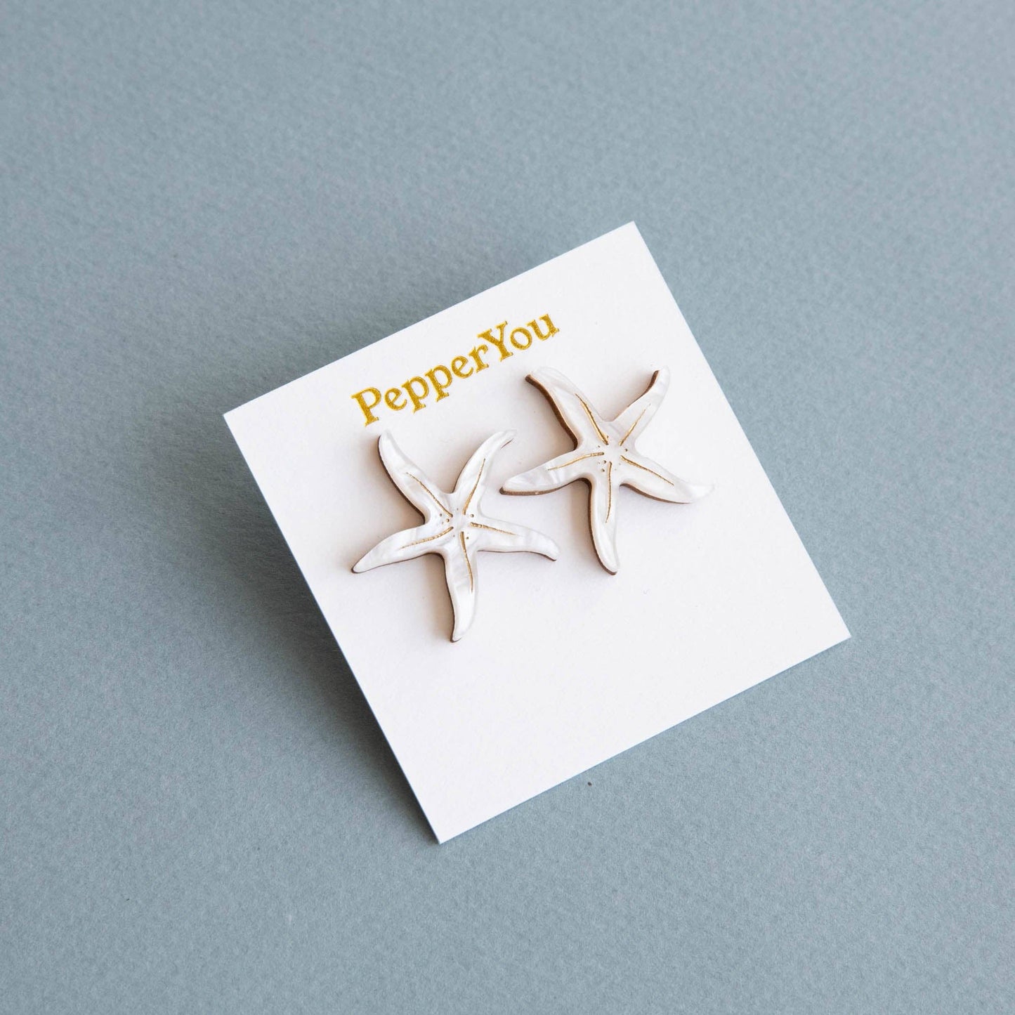 Starfish stud earrings on recycled paper display card