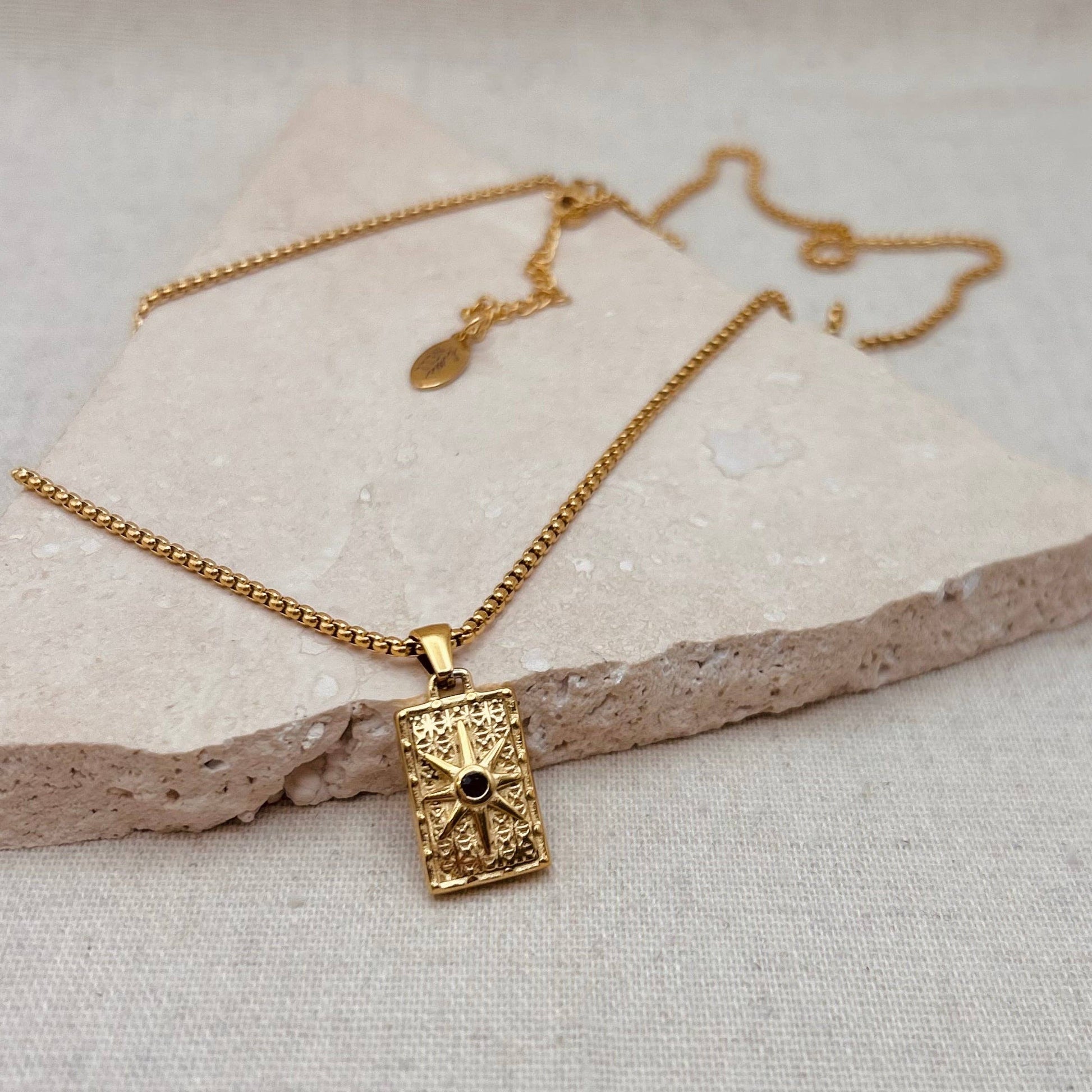 Little Nell Long Noir Rectangle Necklace with gold pendant and black star detail on adjustable 60cm chain.