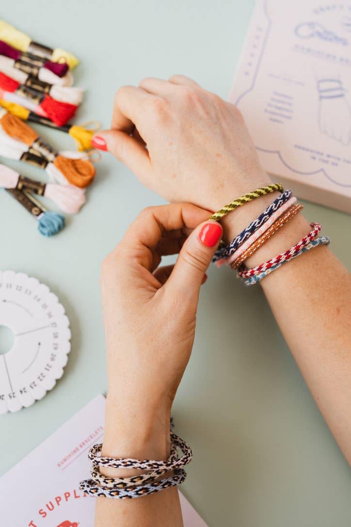 Kumihimo kit box showing finished bracelet examples