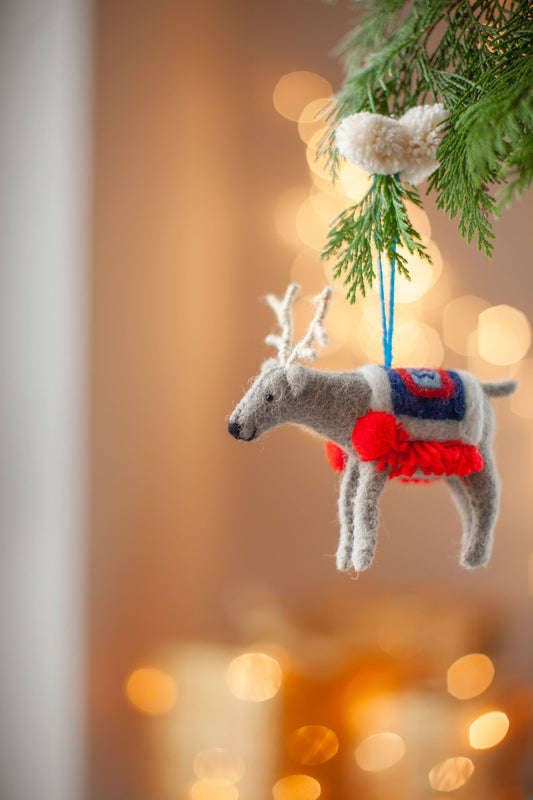 Close-up of Randolph Reindeer Christmas ornament, detailed embroidery and wool rug, eco-friendly festive decor