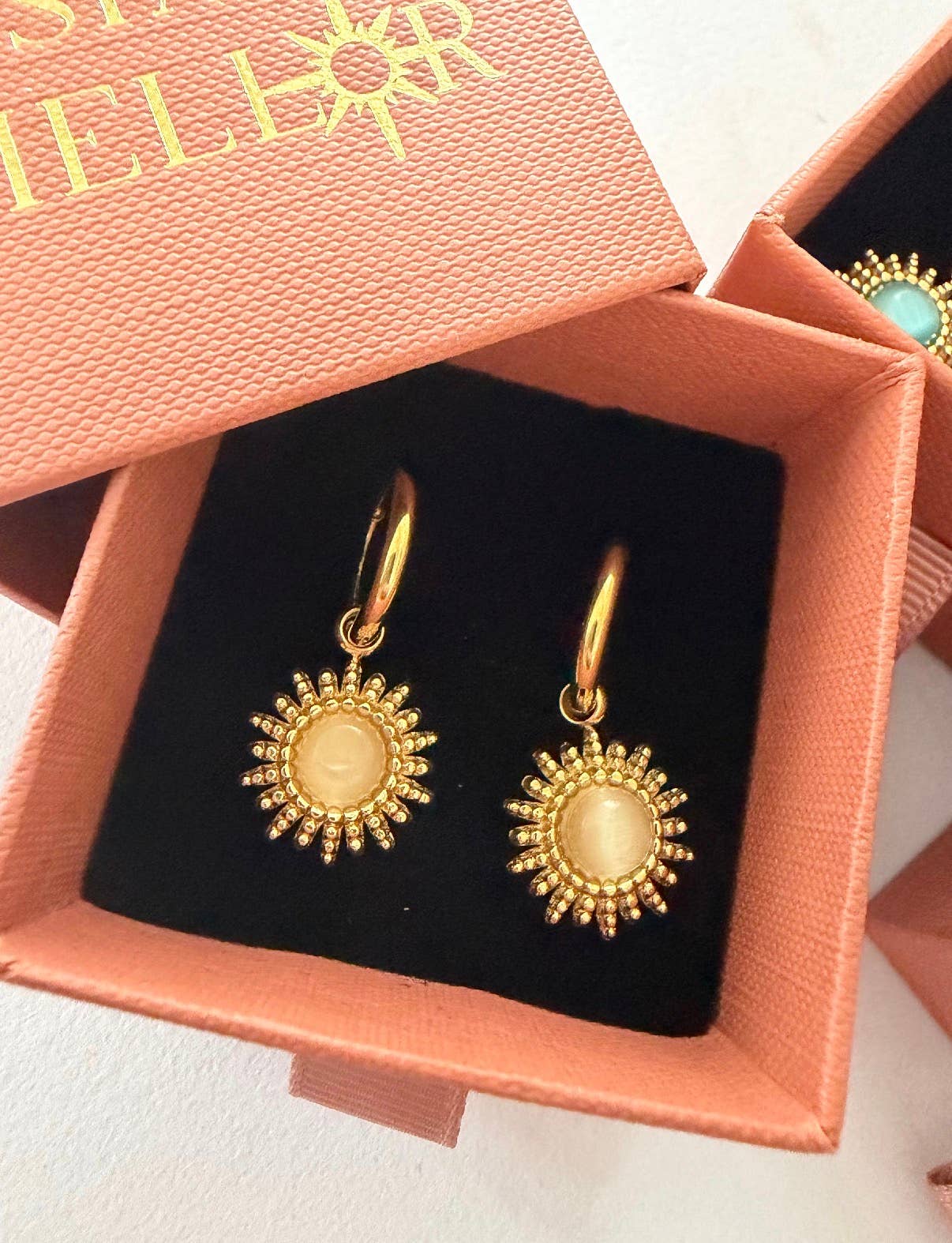 Close up of white 18k gold plated sun hoop earrings