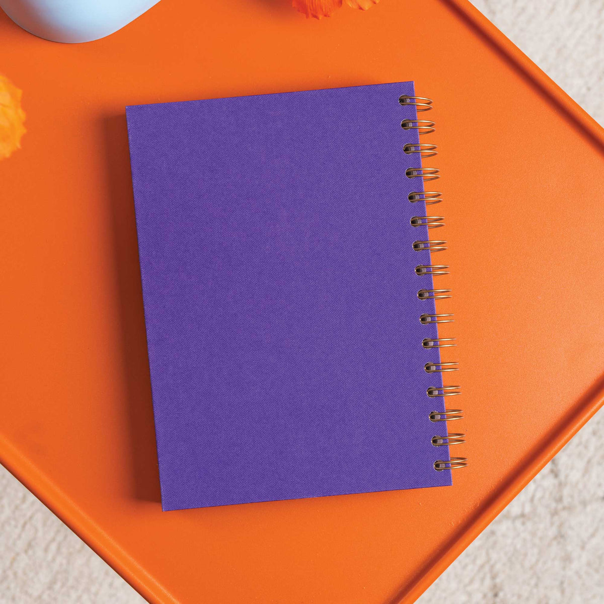 Recycled paper pages of purple undated planner showing bronze wire binding