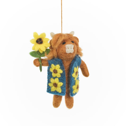 A handmade felt decoration resembling a Highland cow with a floral patterned waistcoat and a sunflower, named Harrison.