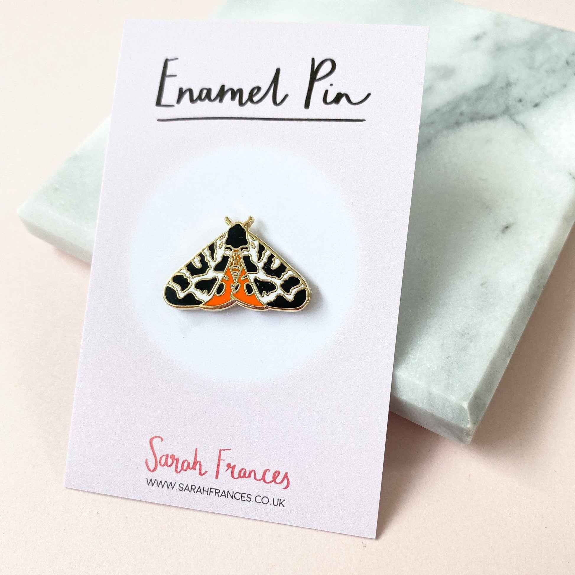 Tiger Moth Enamel Pin by Sarah Frances, 1 inch gold metal with hard enamel red and black garden moth design, pink rubber clutch back.