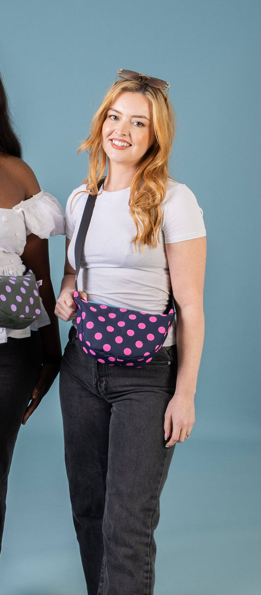 Pink and navy polka dot waxed cotton sling bag front view