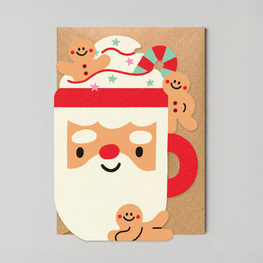 Charming die-cut Christmas card featuring a Santa mug overflowing with cream and gingerbread, designed by Edyta Demurat. Eco-friendly, plastic-free, blank inside, and made in the UK.