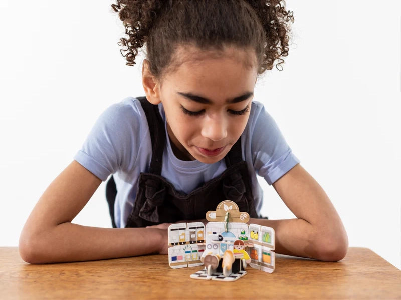 Playpress Mini Refill Café Playset is pocket-sized and wonderful for inspiring imaginative play. With this pack, you’ll be able to build a mini café and assemble a variety of accessories, including miniature food items, a coffee machine, and cash. A shop assistant and customer are also included. Made from our sustainable sourced FSC® (FSC-C004309) certified Playboard, this playset is not only environmentally friendly, but also durable and long-lasting.