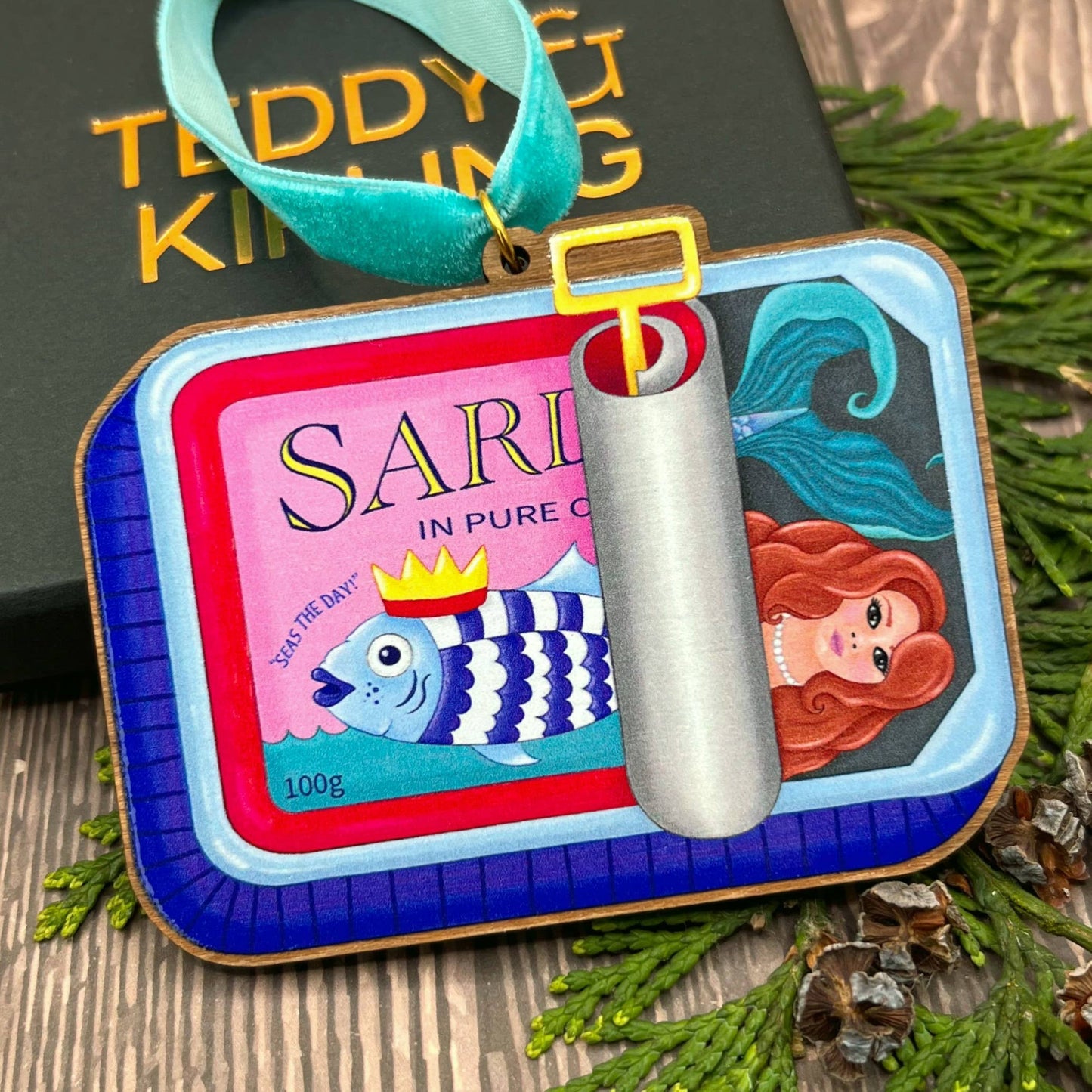 Sardine Tin Mermaid wooden Christmas tree decoration with Teddy & Kipling illustration, sustainably certified cherry wood, gold-plated ring, and turquoise velvet ribbon