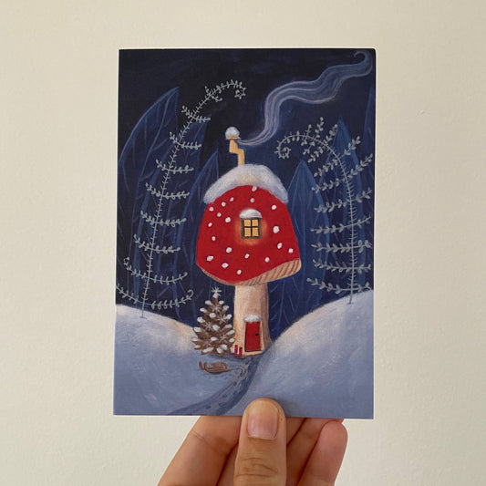 Enjoy the whimsical charm of this Toadstool home cosy card, featuring a wintry scene with smoke billowing from the chimney and snow dusting the surroundings on a cold winter night.