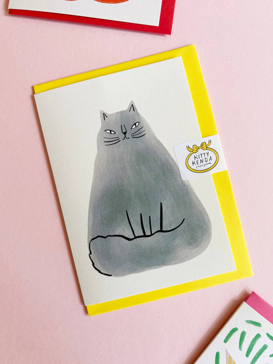 A heartfelt illustration of the "Floofiest" cat ever, exclusive to Kitty Kenda Papergoods. White card, with an illustrated  large grey floofy cat