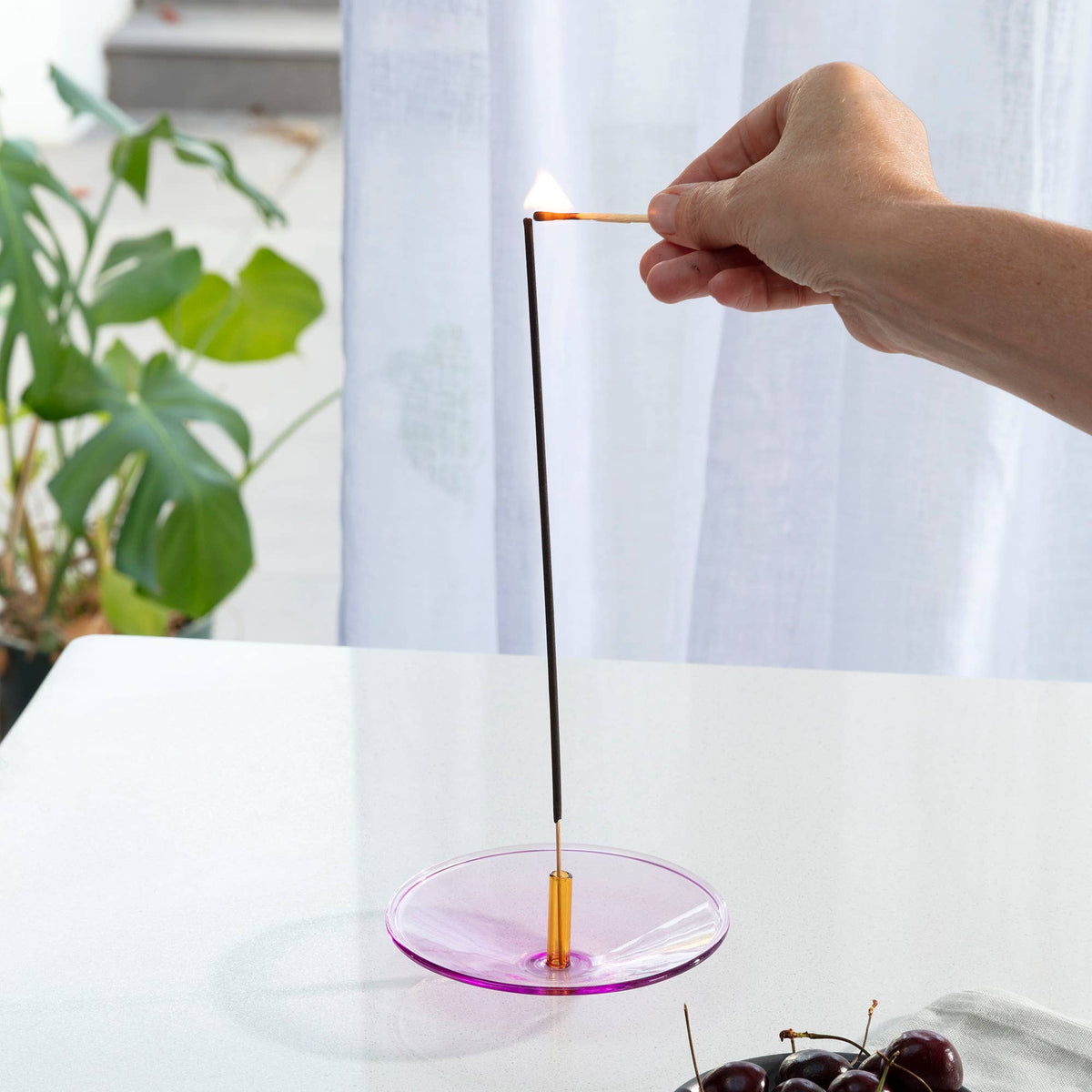 Sculptural colour block glass incense burner on table