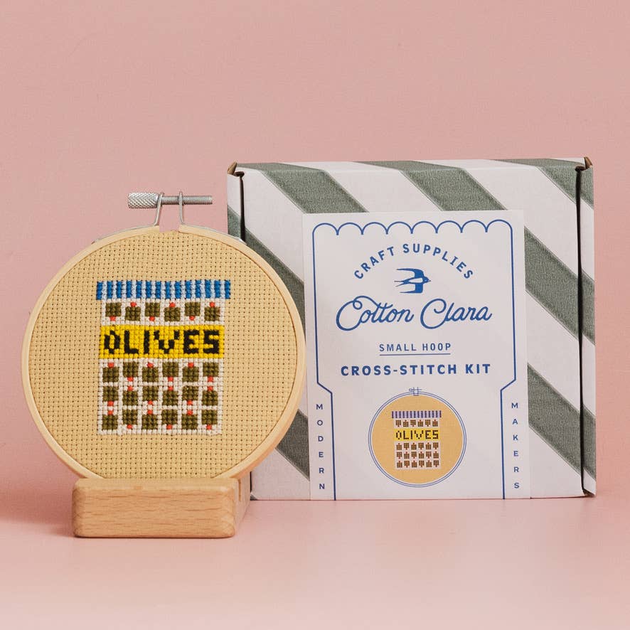 Olives Mini Cross Stitch Kit with 11cm wooden hoop, vibrant Aida fabric, threads, and needle for a sustainable craft project.
