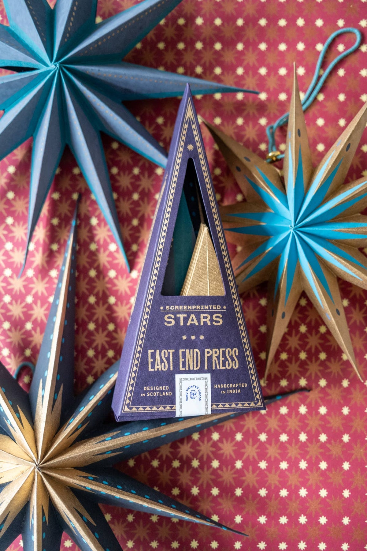Close-up of artisan hand-printed board star ornament with cotton loop