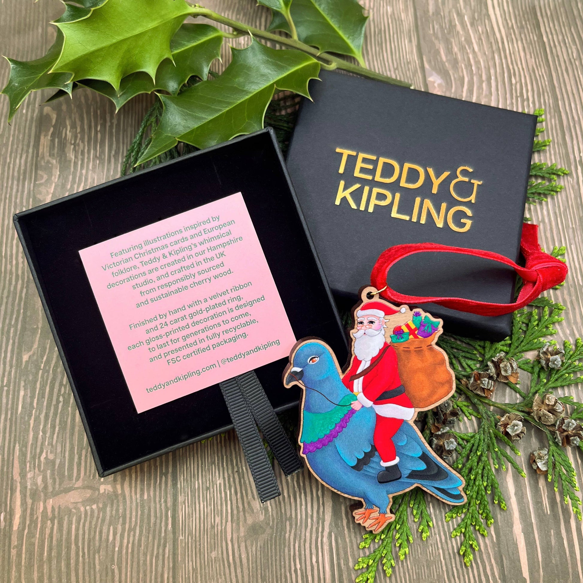 Santa Pigeon wooden Christmas tree decoration with Teddy & Kipling illustration, sustainably certified cherry wood, gold-plated ring, and red velvet ribbon.