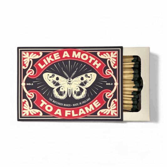 Luxury 'Moth To A Flame' long matchbox on a mantlepiece, close-up showing elegant design and extra-long matches
