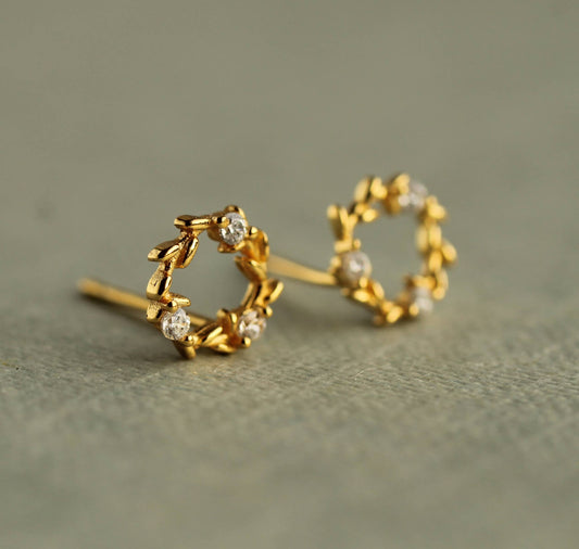 These charming and unusual stud earrings feature a miniature laurel leaf design, with cubic zirconia crystals formed to create a fluid, Art Nouveau inspired design. The earring posts and butterfly backs are gold plated 925 sterling silver. 