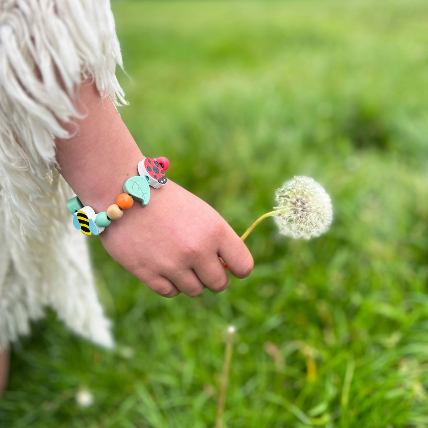 Eco-friendly bracelet craft kit with insect and leaf beads, presented in gift tin