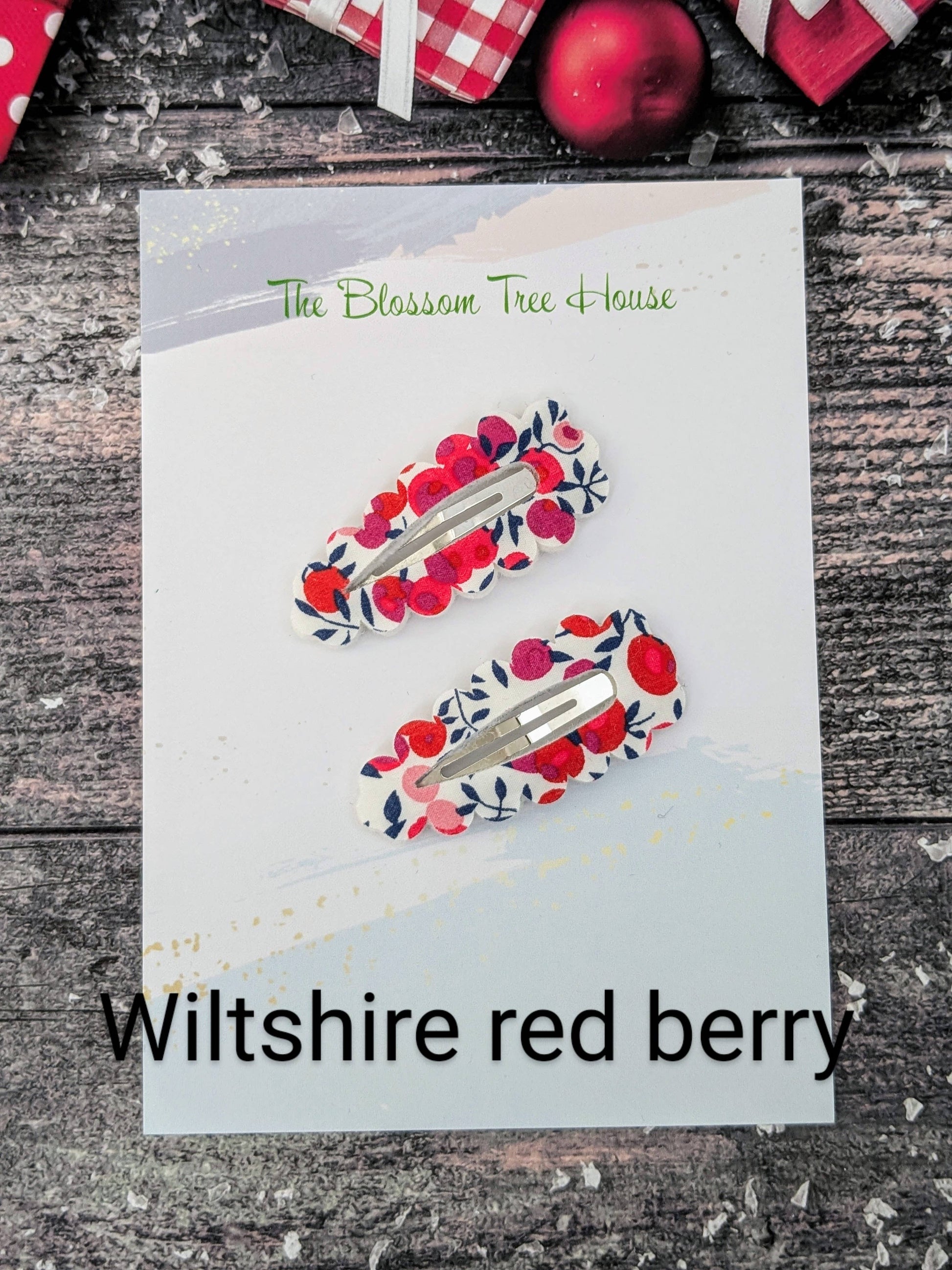 Two hair clips with red berry design on a card labeled 'Wiltshire red berry' by 'The Blossom Tree House'.