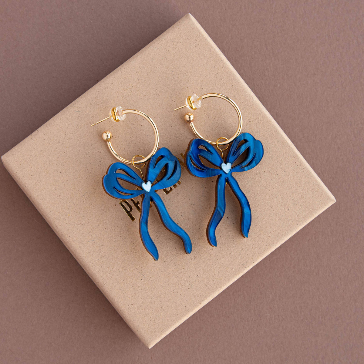 Detailed view of heart cutouts on bow hoop earrings
