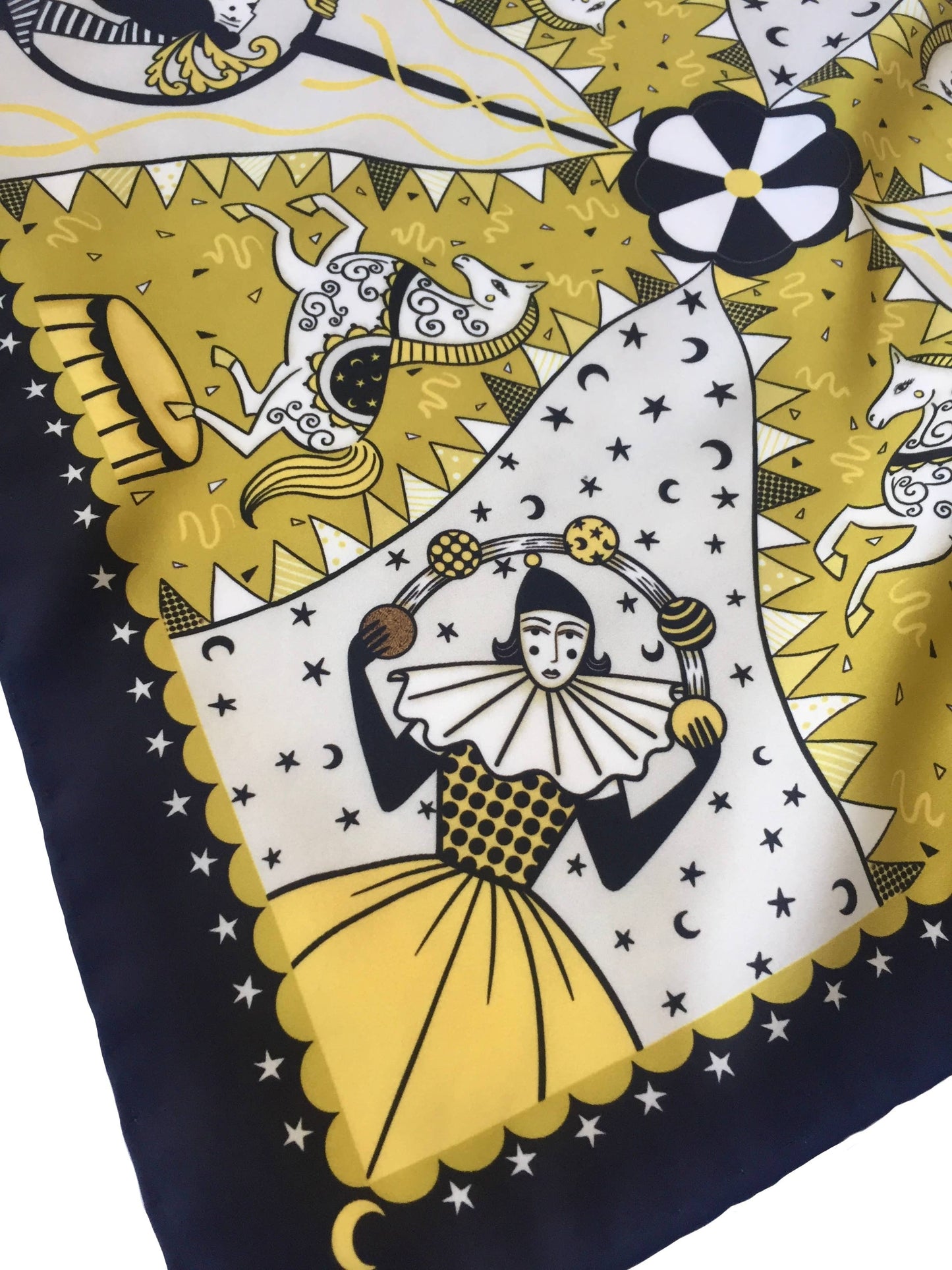 Eco silk twill pocket square with original Night Circus print by Su Owen; features Pierrot juggler, aerialist, horses, moons, and stars. Golden yellow, ivory, and dark chocolate colours. Made from 100% recycled polyester.